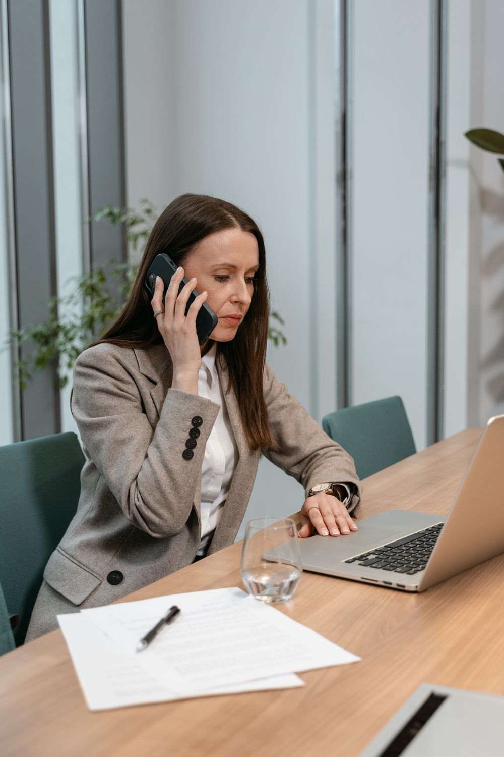 Profissional atendendo um cliente ao telefone, com notebook na mesa